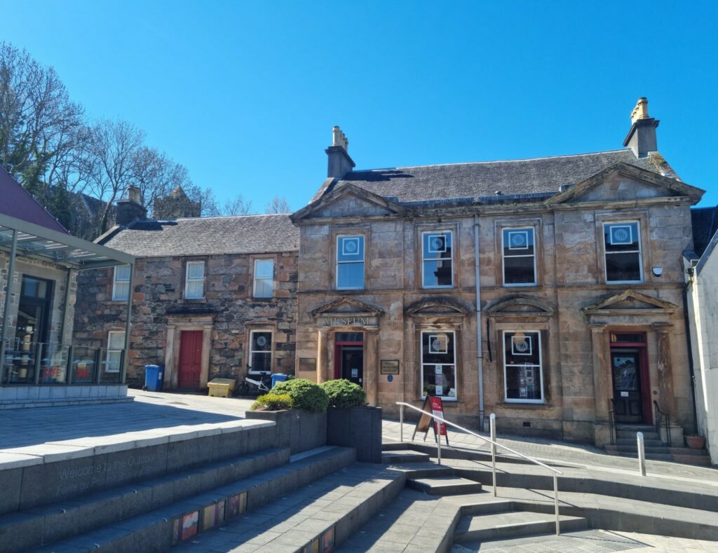 The West Highland Museum building with Cameron Square in the foreground and blue skies