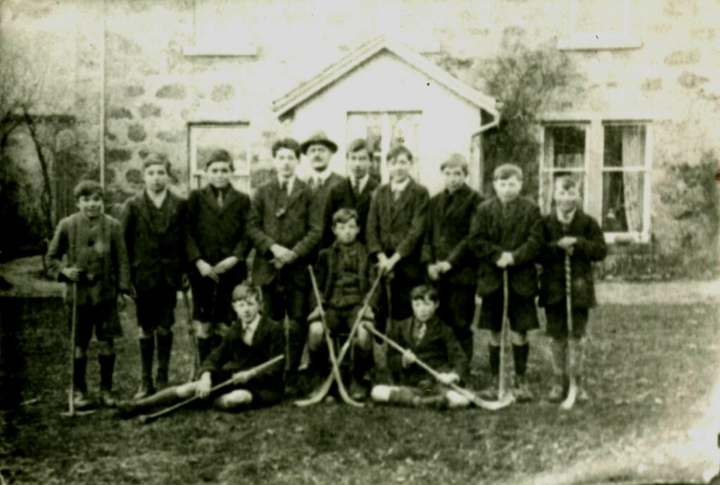 black and white photograph of children with shinty sticks